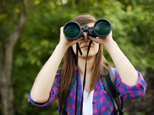 Frau beobachtet Vögel mit einem Fernglas Vogelbeobachtung_shutterstock_126072356.jpg
